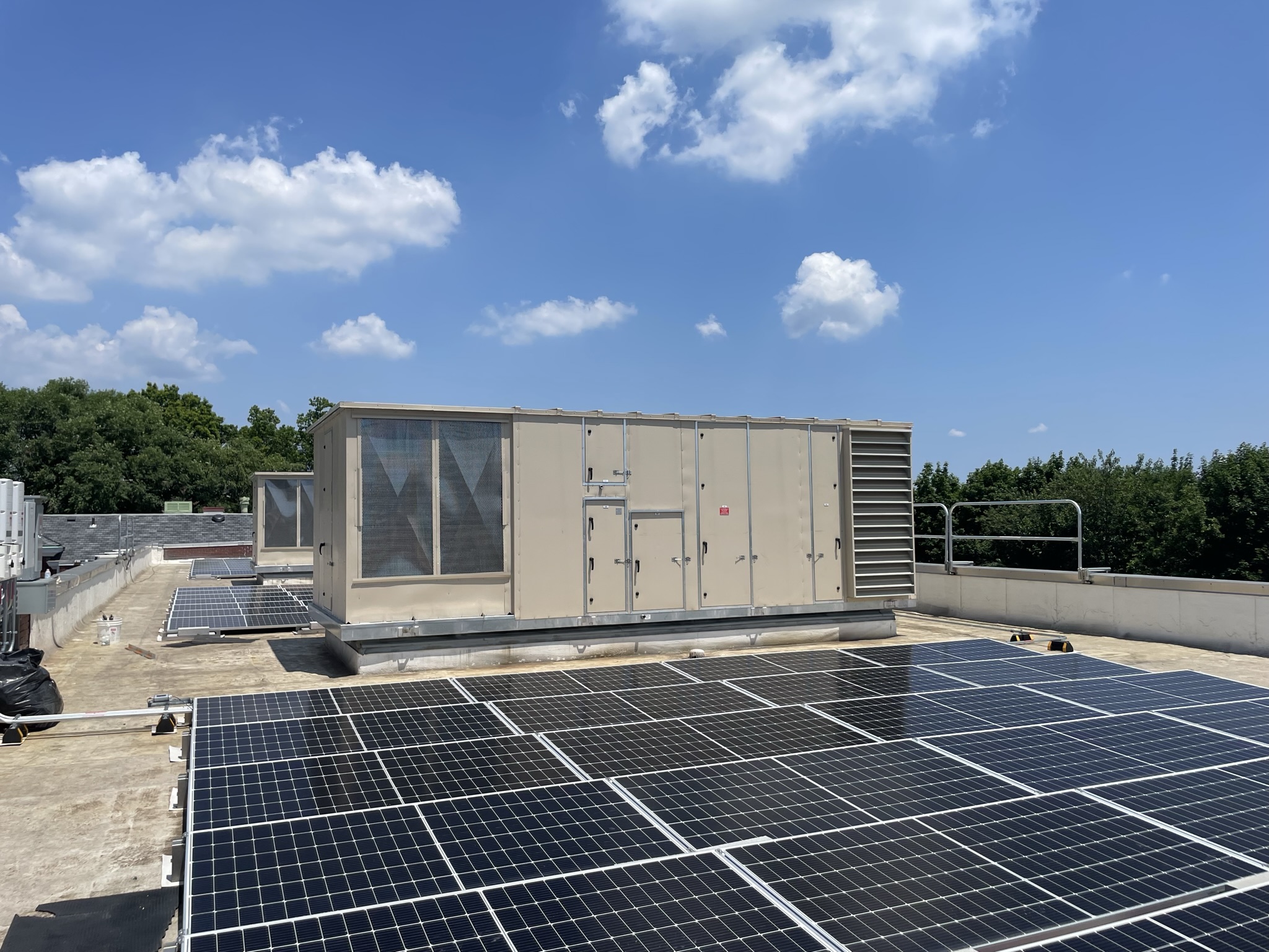 Air handling equipment installed beside rooftop solar panels